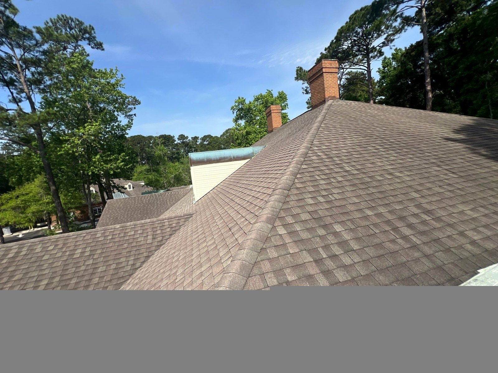 Completed shingle roof replacement with brick chimneys on home in Hilton Head Island SC